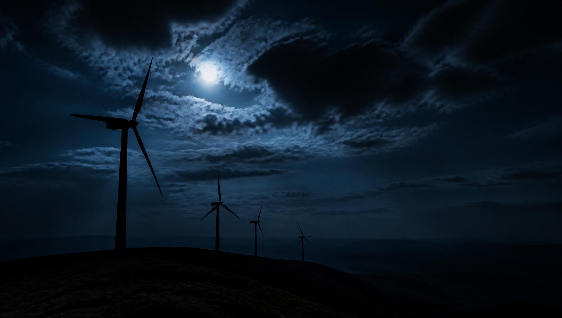 Wind turbines on a dark hill at dusk
